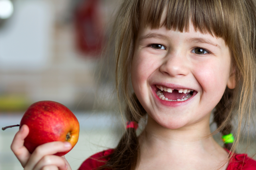 young girl eats apple