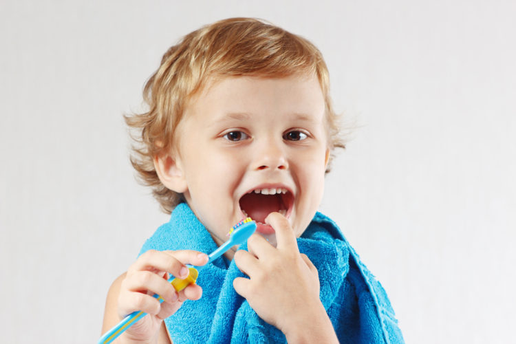 young child brushes his teeth