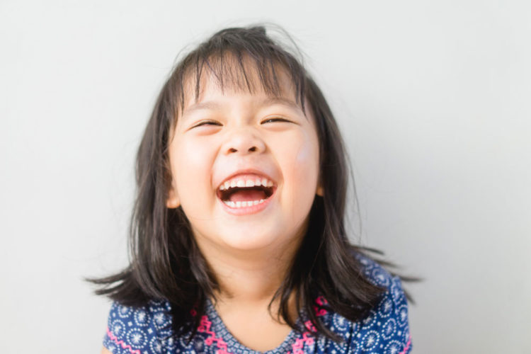 Girl laughing and showing teeth.