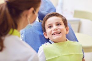 Young boy sitting in a dentist's chair and smiling
