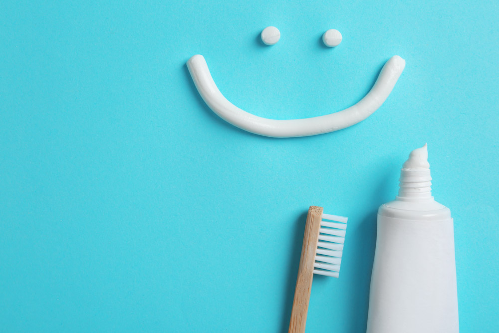 Smiling face made of toothpaste, tube, and brush