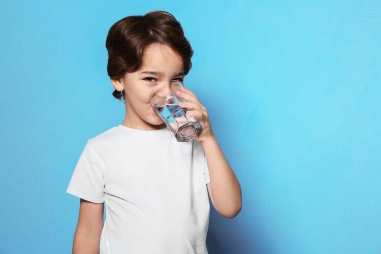child drinking water with fluoride to supplement pediatric dentist treatment