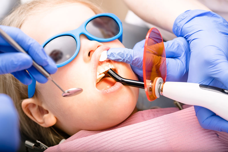 A young girl getting a filling at the dentist