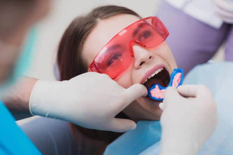 dentist applies fluoride treatment to girl