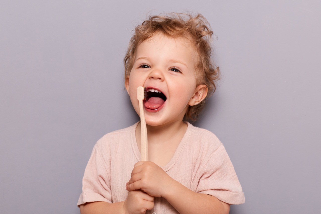 laughing kid holds up a tooth brush